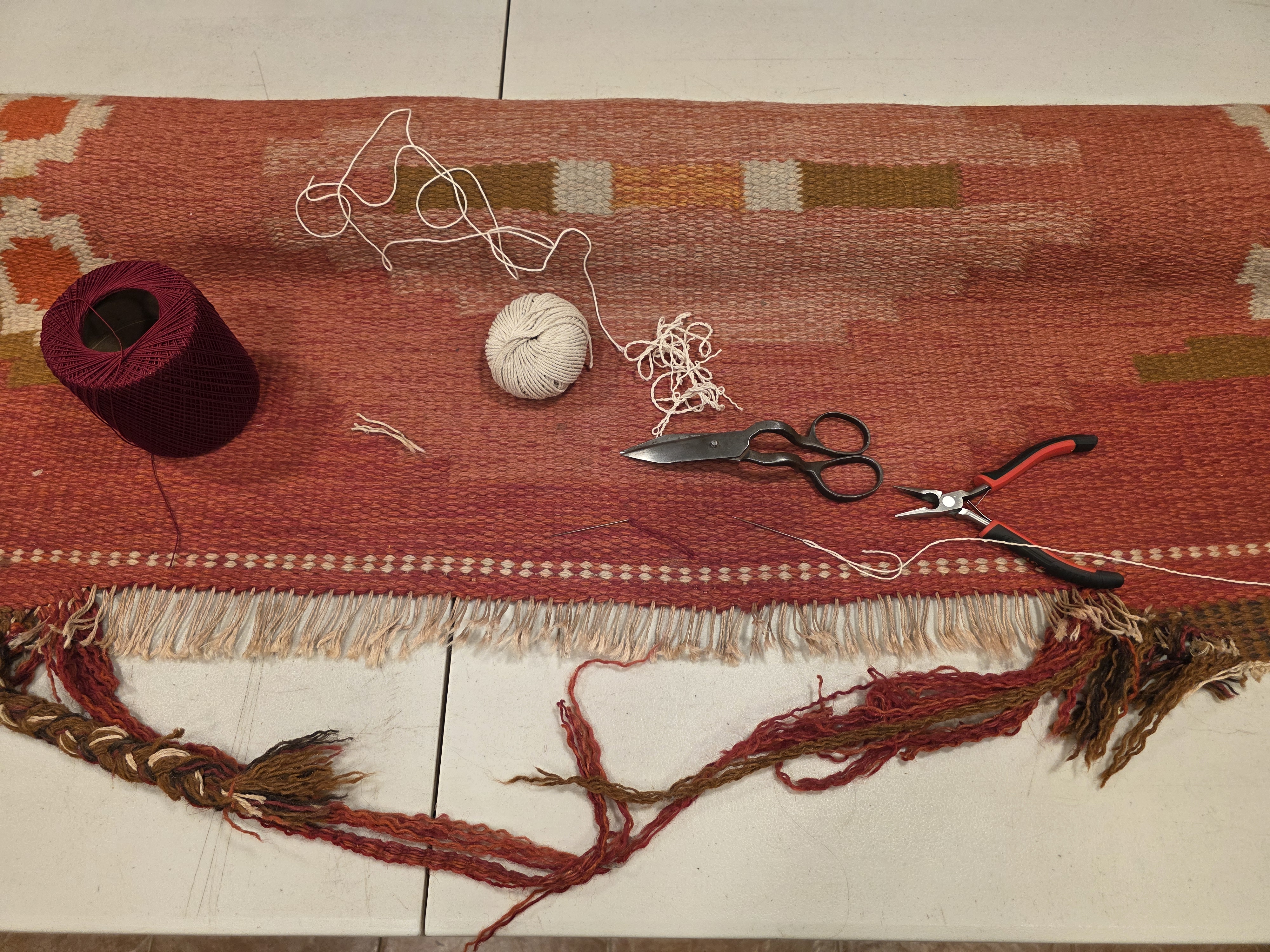 Damaged kilim edge before repair with loose and missing fibers