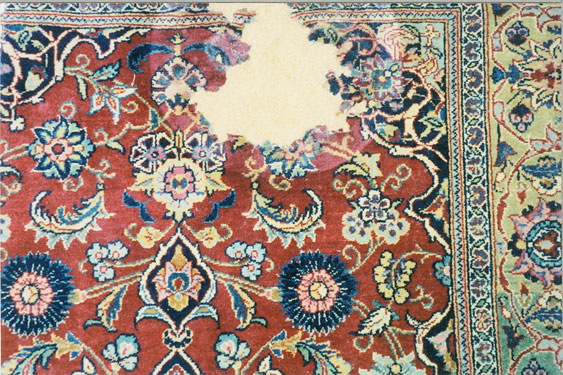 Oriental rug with a large worn area before repair